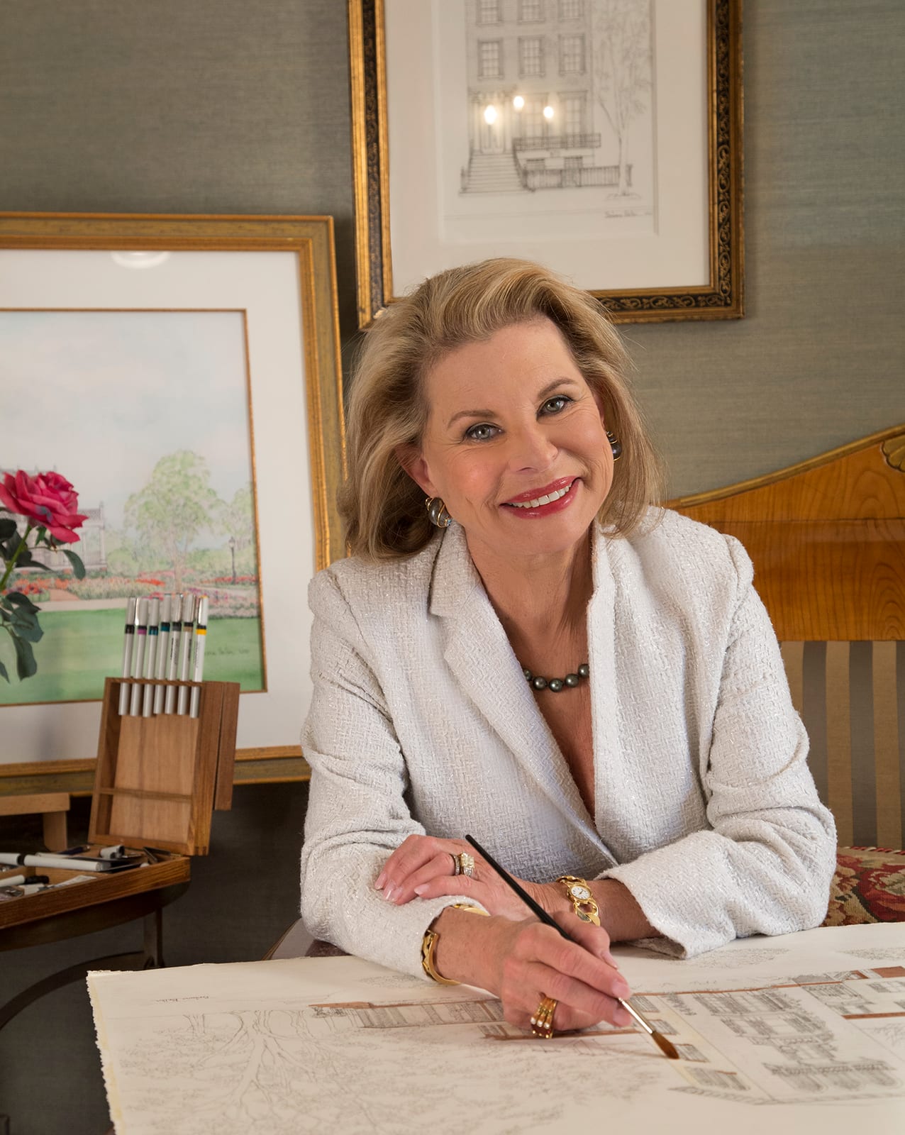 Artist Barbara Bellin painting a house portrait at her desk